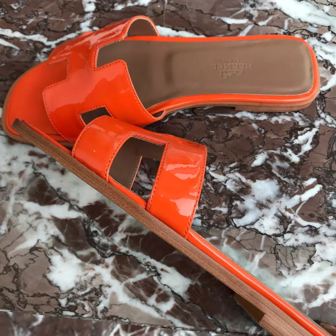HERMES ORAN SLIDE SANDALS IN ORANGE PATENT CALFSKIN - HMSD085